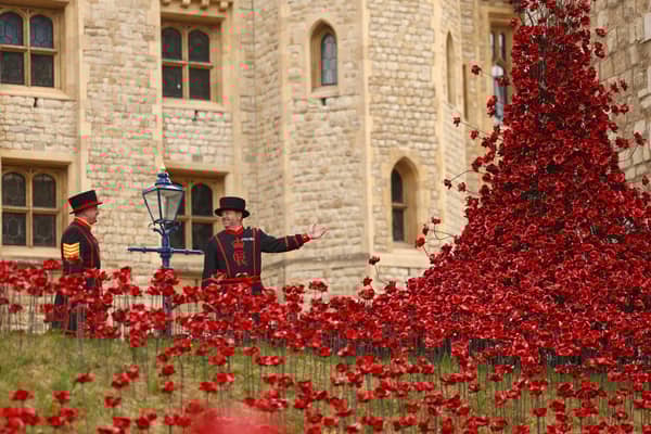 Yeoman Sergeant Dan Benson and Yeoman Warder Andy Sheddon pose for a photograph among a new display of ceramic poppies, called The Tower Remembers, on May 5, 2025 in London