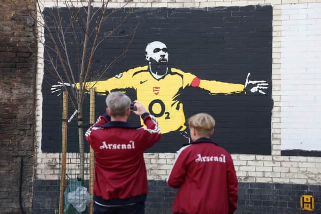 Arsenal fans photograph a mural of former Arsenal player Thierry Henry