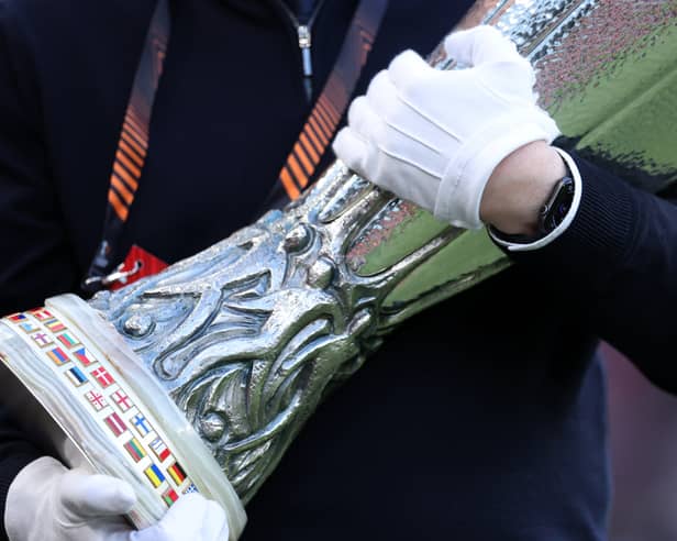 A UEFA official carrying the Europa Cup Trophy 
