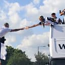 Richarlison of Tottenham Hotspur high-fives a fan during the Tottenham Hotspur UEFA Europa League trophy parade on May 23, 2025 in London, England. Spurs defeated Manchester United in the final in Bilbao on May 21 to win their first major trophy in 17 years.