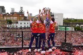Kyra Cooney-Cross, Steph Catley and Caitlin Foord of Arsenal celebrate with the UEFA Women's Champions League trophy during celebrations at Emirates Stadium on May 26, 2025 in London