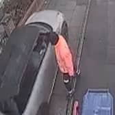 Car drives along pavement to get past bin lorry.