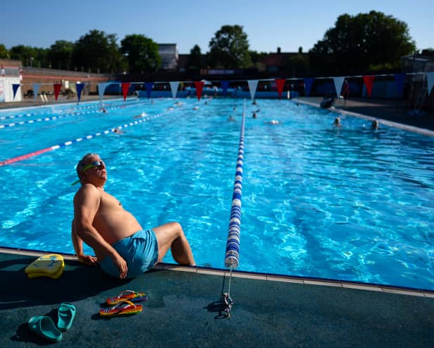 A man glances up at the sun before getting into the pool at Charlton Lido in London