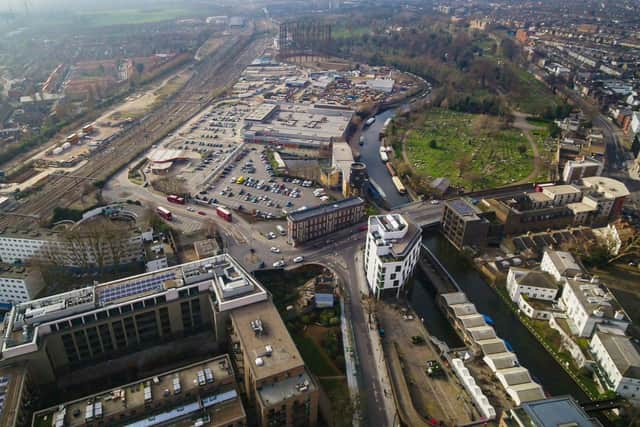 The site currently consists of a supermarket, a carpark, 16 social homes and a disused gasworks network. Aerial shot of Kensal Canalside site in West London, UK.
