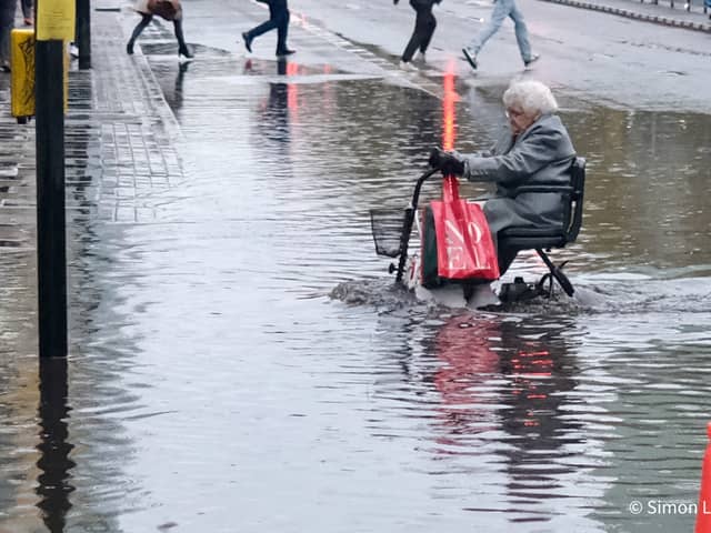 Pensioner using a mobility scooter crosses the Euston Puddle