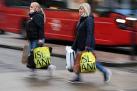 Shoppers carry their purchases from a River Island clothes shop. The retailer has confirmed plans to close 33 UK stores before the end of January 2026 (Photo: DANIEL LEAL/AFP via Getty Images)