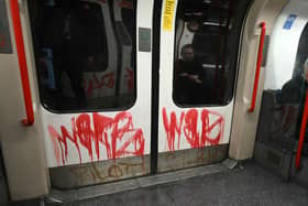 Graffiti is pictured, dawbed on the doors on a Central Line underground train in London