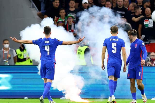 England's Declan Rice gestures towards the fans as a flare is thrown onto the pitch during the 2022 FIFA World Cup Qualifying match at the Puskas Arena, Hungary.