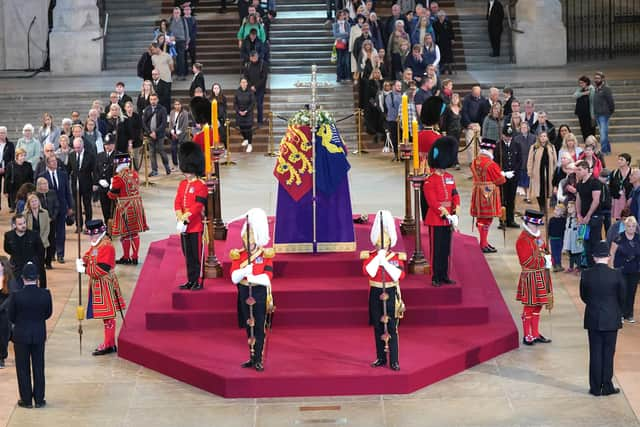 Members of the public file past the coffin of Queen Elizabeth II, draped in the Royal Standard with the Imperial State Crown and the Sovereign's orb and sceptre, lying in state on the catafalque in Westminster Hall, at the Palace of Westminster, London, ahead of her funeral on Monday. Picture: Yui Mok/PA Wire