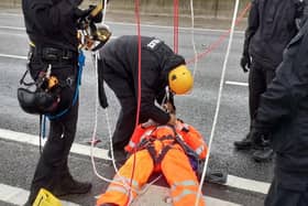 A Just Stop Oil protester being detained after they climbed a gantry on the M25, leading to the closure of the motorway. 