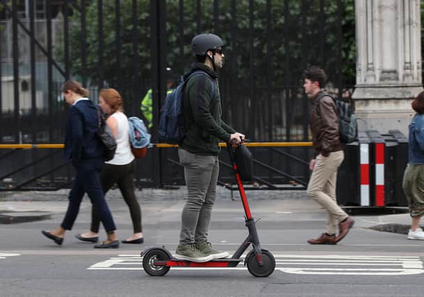 A person riding an electric scooter in Westminster, London.