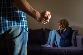 PICTURE POSED BY MODEL A man stands with a clenched fist as a woman cowers in the corner.