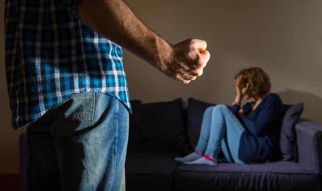 PICTURE POSED BY MODEL A man stands with a clenched fist as a woman cowers in the corner.