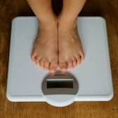 A young child is weighed on scales.