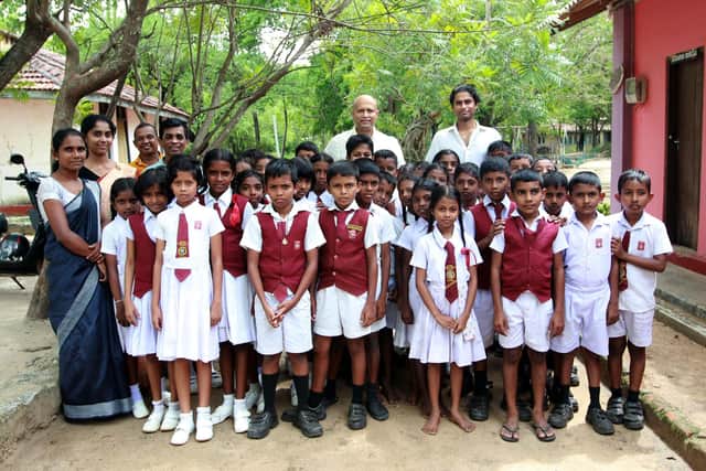 (Back row centre) Saman Nammunige, Features Journalist, Sujith Weerasinghe, Specsavers North West London Regional Relationship Manager and Dilmith Weerasinghe with pupils and teachers from the primary school in Polonnaruwa, Sri Lanka.