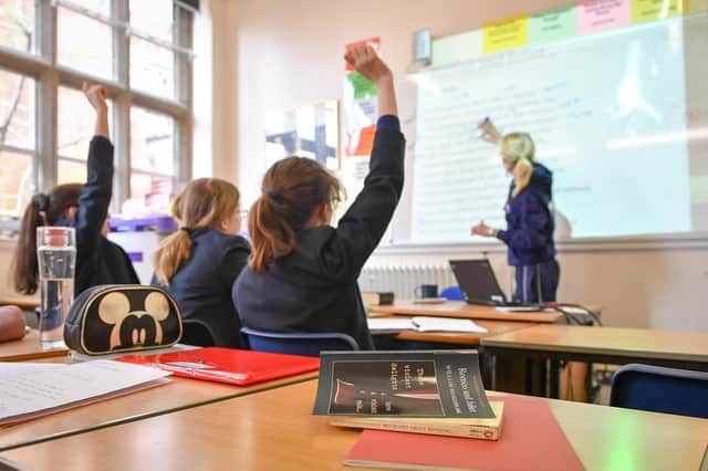 File photo dated 12/09/18 of a teacher and students in a classroom, as the Government's plan for all state schools to deliver at least a 32.5 hour week has been pushed back by a year.