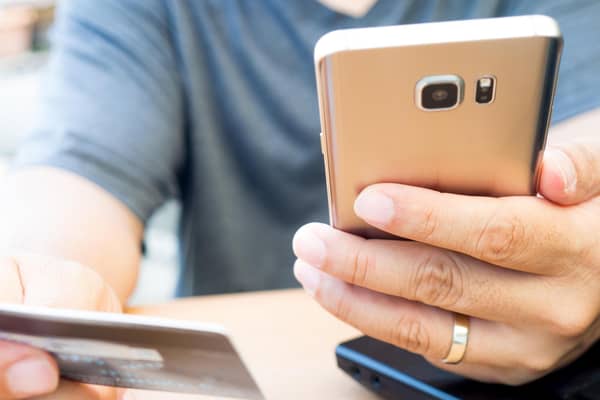 A person looks at their bank card and mobile phone. PIC: Alamy/PA