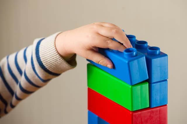 File photo dated 24/01/16 of a preschool age child playing with plastic building blocks. Parents have less time to read, play, and cook healthy meals with their children as a result of the cost-of-living crisis, according to a new poll. Issue date: Monday September 11, 2023.