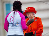 Queen Elizabeth II passes her baton to the baton bearer, British parasport athlete Kadeena Cox. (Photo by Victoria Jones - WPA Pool/Getty Images)