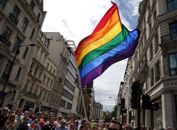 A rainbow flag is held aloft as the Pride in London parade makes its way through the streets of central, London.