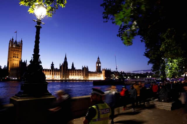A police officer stands guard as members of the public stand in line as they queue along Embankment, with the Palace of Westminster, house of Parliaments and Elizabeth Tower, commonly referred to as Big Ben, in the background. Picture: Odd Andersen/AFP via Getty Images