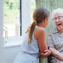 A young girl and an elderly lady are laughing together