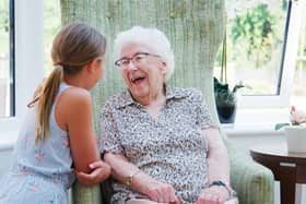 A young girl and an elderly lady are laughing together