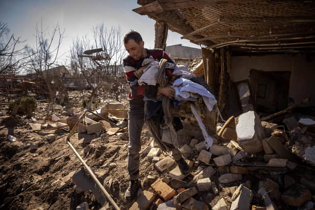 A man collects clothes from the remains of a house in the city of Zhytomyr, northern Ukraine (Picture: Fadel Senna/AFP via Getty Images)