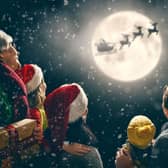 People looking up at the night sky at Santa on his sleigh.