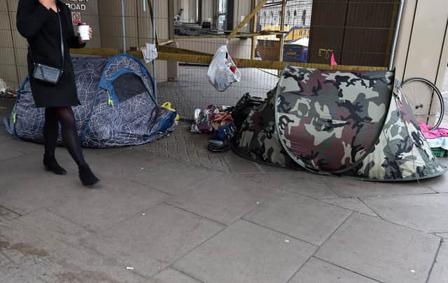 A woman walks past tents of the homeless in Victoria, London. PA Photo. Picture date: Thursday January 16, 2020. Photo credit should read: Nick Ansell/PA Wire