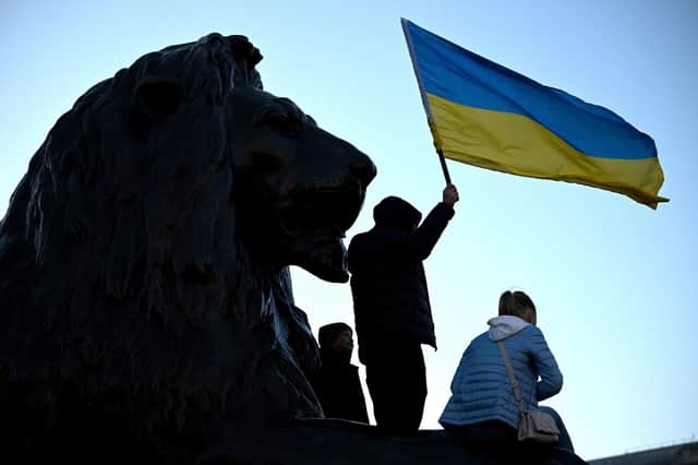LONDON, ENGLAND - FEBRUARY 27: A young protester holds a Ukrainian flag as they gather for a demonstration in support of Ukraine in Trafalgar Square on February 27, 2022 in London, England. Russia's large-scale invasion of Ukraine has killed scores and prompted a wave of protests across Europe. (Photo by Leon Neal/Getty Images)