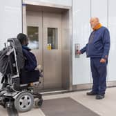A customer in a motorised wheelchair uses a London Overground lift