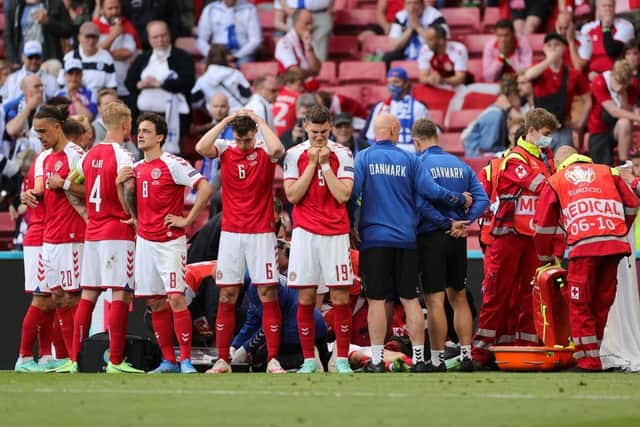 Distraught Denmark team mates shield stricken Christian Eriksen as medical staff work to keep him alive.