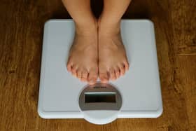 A young child is weighed on scales.