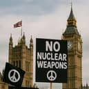 Protesters rally outside the UK Parliament against nuclear weapons expansion.