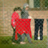 A view of people thought to be migrants at the Manston immigration short-term holding facility located at the former Defence Fire Training and Development Centre in Thanet, Kent. 700 people were moved to the Manston facility for safety reasons after incendiary devices were thrown at a Border Force migrant centre in Dover on Sunday. Picture date: Monday October 31, 2022.
