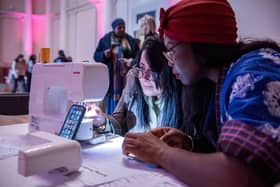 Visitors try out a sewing machine at the Shoreditch Town Hall Fun Palace.