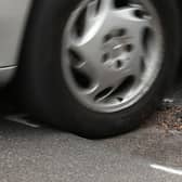File photo dated 11/05/18 of a car hitting a pothole on a road. Drivers are suffering from a surge in pothole-related breakdowns, new figures from the RAC suggest.