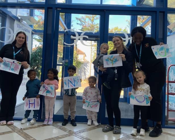 Monkey Puzzle Chadwell Heath children and staff holding up thank you sign.