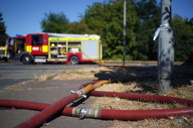 London Fire Brigade dealing with the aftermath of a grass fire in Rainham, east London. The Met Office has issued an amber warning for extreme heat covering four days from Thursday to Sunday for parts of England and Wales as a new heatwave looms. Picture date: Wednesday August 10, 2022.