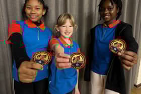 Members of 6th Croydon Guides, Megan, Harriet and Atinuke, with their Black History Month badges.