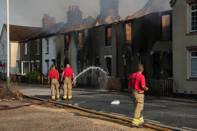 Houses in Wennington, east London, burn after grass fires spread into the village during the heatwave earlier this week (Picture: Carl Court/Getty Images)