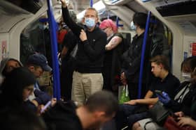 Commuters, some wearing PPE (personal protective equipment), including a face mask as a precautionary measure against COVID-19, stand on a busy Transport for London (TfL) (Photo by TOLGA AKMEN/AFP via Getty Images)