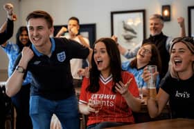 England football fans celebrating in a pub.