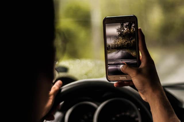 It is now illegal for UK motorists to use their mobile phones for any purpose