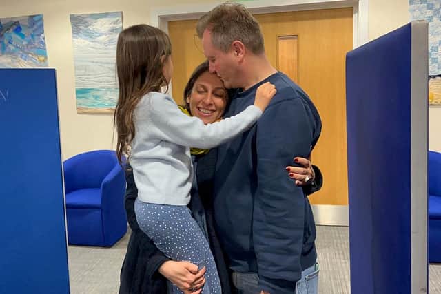 A handout picture released by the Free Nazanin campaign group shows Nazanin Zaghari-Ratcliffe (C) hugging her husband Richard Ratcliffe (R) and their daughter Gabriella upon her arrival at RAF Brize Norton early on March 17th. Photo: HANDOUT/Free Nazanin campaign/AFP via Getty Images.