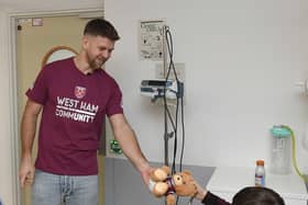 Niclas Füllkrug passes a gift to a young fan at King George's Hospital