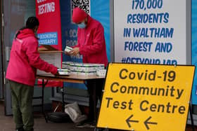 People arrange boxes at a free Covid-19 rapid lateral flow test kit handout point on Hoe Street in Walthamstow, north London on December 30, 2021. Photo by TOLGA AKMEN/AFP via Getty Images