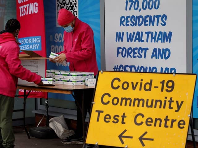 People arrange boxes at a free Covid-19 rapid lateral flow test kit handout point on Hoe Street in Walthamstow, north London on December 30, 2021. Photo by TOLGA AKMEN/AFP via Getty Images